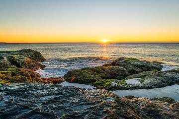 Sunrise over rocks and waves Australia