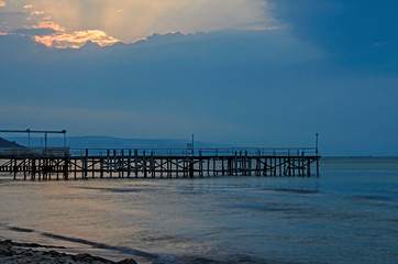 Sunset at the Black Sea shore from Albena, Bulgaria with golden sands, blue mystic water, seaside bridge