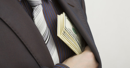 Man hides in his pocket the banknotes one hundred dollars