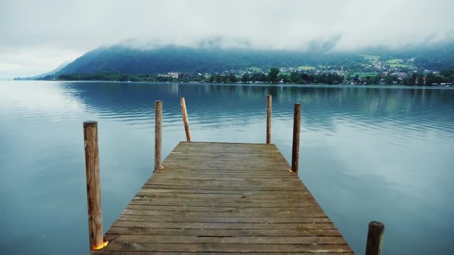 Wooden pier on a picturesque mountain lake in the Alps in Austria. Steaducam shot
