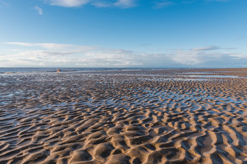 Beautiful blue sky and textured sand, on a sunny day at the beach