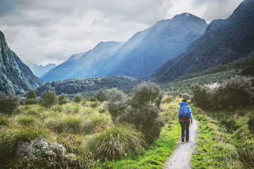 Naklejka na ściany i meble Woman with backpack hiking at Kepler Great walk, New Zealand. Adventure lifestyle concept