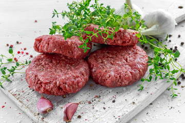 Home HandMade Raw Minced Beef steak burgers on wooden board.