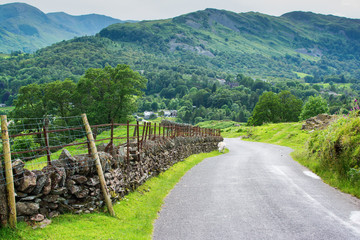 Roadside views in Lake District National Park, England, stone wall and the mountains, selective focus