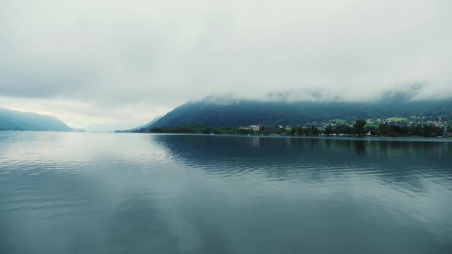 Mountain lake in the Austrian alps. Fog, early morning. Pan shot