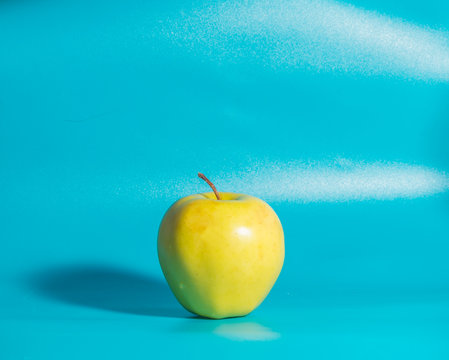 on  blue background yellow Apple, close up.