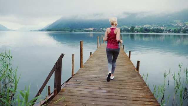Morning jogging near the picturesque mountain lake in the Austrian Alps. Steadicam shot