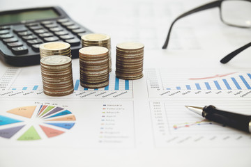 Obraz premium Row of coins,calculator with account book finance and banking concept for background.concept in grow and walk step by step for success in business. concept of saving money.