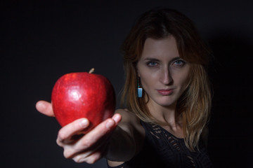 young woman stretches red apple