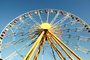 Half of a colorful ferris wheel. Clear skies.