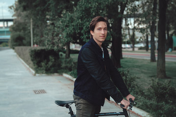 A man is riding a bicycle in a park on the waterfront