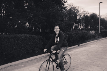 A man is riding a bicycle in a park on the waterfront