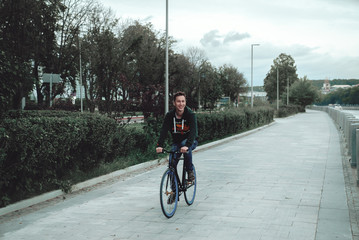 A man is riding a bicycle in a park on the waterfront