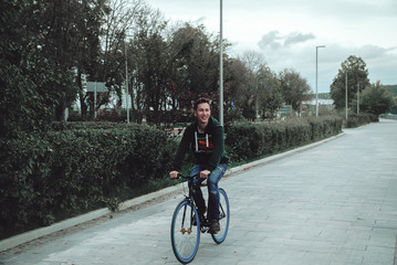 A man is riding a bicycle in a park on the waterfront