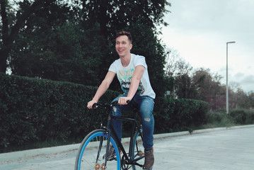 A man is riding a bicycle in a park on the waterfront