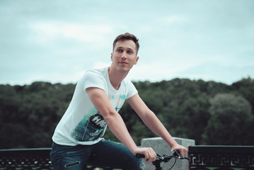 A man is riding a bicycle in a park on the waterfront