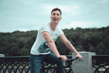 A man is riding a bicycle in a park on the waterfront