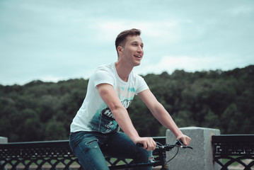 A man is riding a bicycle in a park on the waterfront