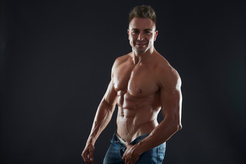 Fototapeta na wymiar Handsome muscular fit young man on studio background 