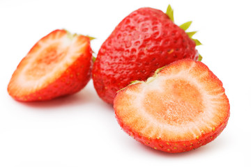 Red ripe strawberries, whole and sliced halves isolated on white. Shallow focus.