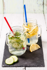 Two mugs of infused detox diet refreshing waters: with cucumber and lemon