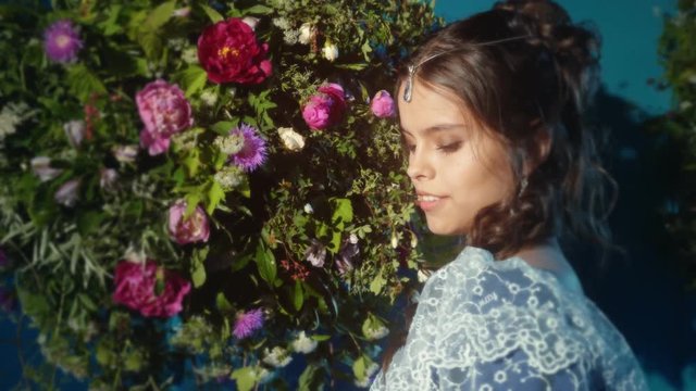 Beautiful young woman walking next to flower arrangement