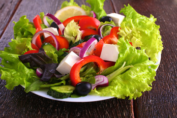 salad from fresh vegetables in a plate on a table, selective focus