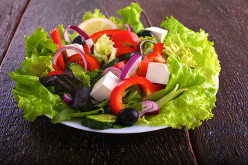 salad from fresh vegetables in a plate on a table, selective focus