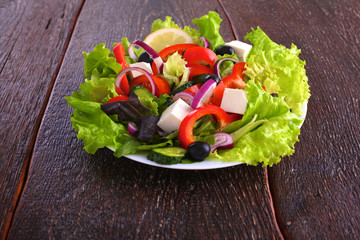 salad from fresh vegetables in a plate on a table, selective focus