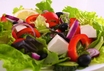 salad from fresh vegetables in a plate on a table, selective focus