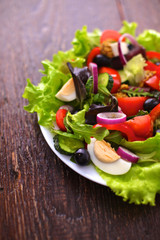 salad from fresh vegetables in a plate on a table, selective focus