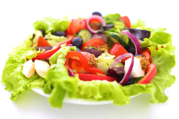 salad from fresh vegetables in a plate on a table, selective focus