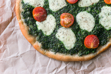 Appetizing pizza with pesto mozzarella and cherry and chili peppers