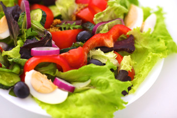 salad from fresh vegetables in a plate on a table, selective focus