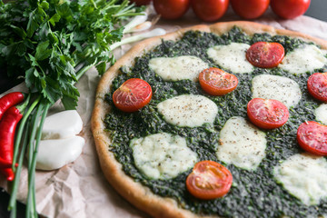 Appetizing pizza with pesto mozzarella and cherry and chili peppers