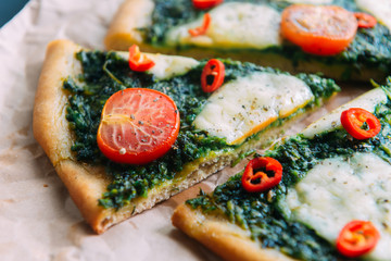 Appetizing pizza with pesto mozzarella and cherry and chili peppers