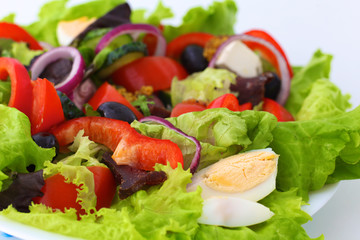 salad from fresh vegetables in a plate on a table, selective focus