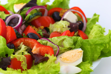 salad from fresh vegetables in a plate on a table, selective focus