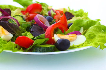 salad from fresh vegetables in a plate on a table, selective focus