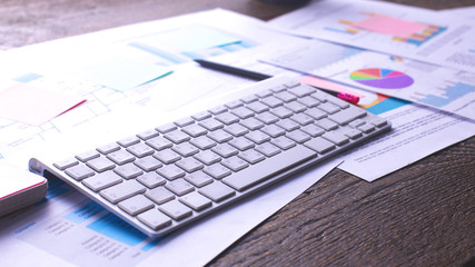 Architectural blueprints and blueprint rolls and a drawing instruments on the worktable