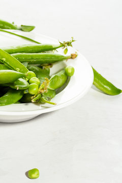 Green peas in a plate on a white background.