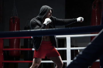 Boxer man workout in boxing ring. Boxing fighter in hoodie - Powered by Adobe