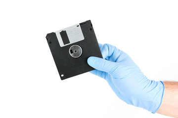 Hand With Gloves Holding Old Floppy Disks On Isolated Background