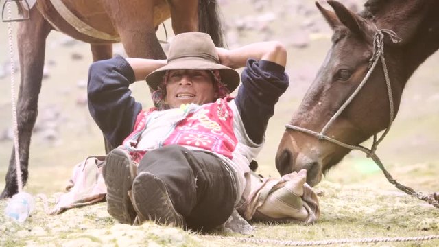 Peruvian muleteer resting near horse wearing the typical costume of the highlands. Slow motion