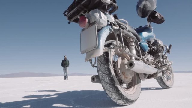 Male biker walks near the motorcycle, trip motorcycle adventure. Slow motion.