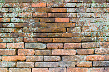 Old brown brick wall with moss stains