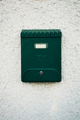 Green beautiful old fashioned mailbox on white wall background.