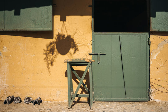 Empty stable for horses with green door and yellow wall on ranch