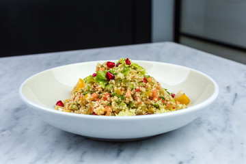 Quinoa salad with pomegranate in white plate