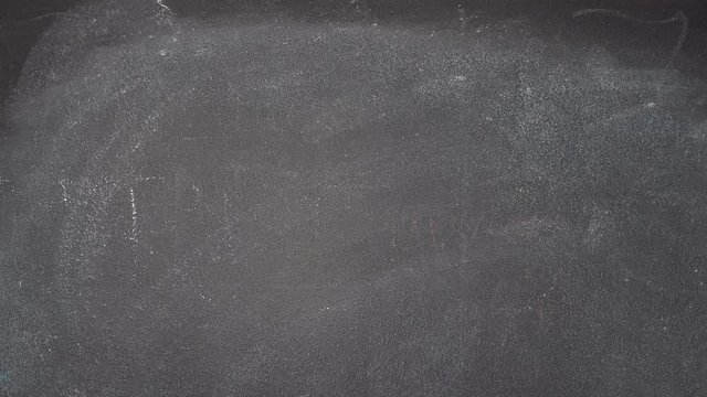Woman's hand writing "RULES" with white chalk on blackboard
